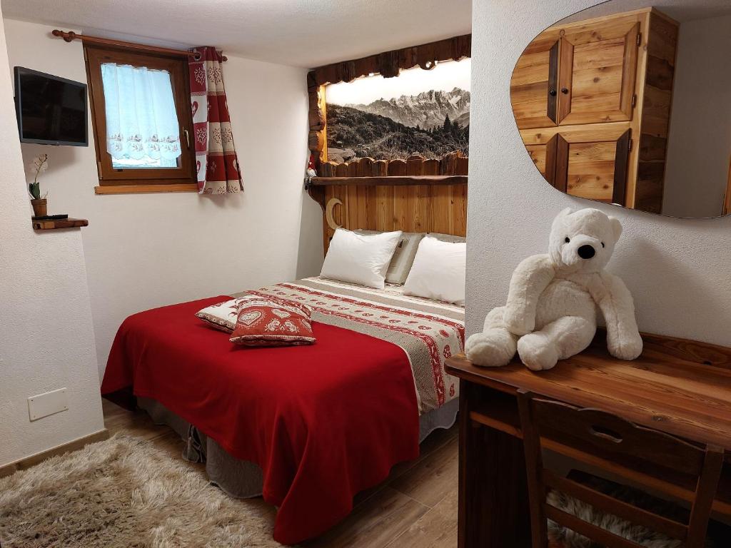 a teddy bear sitting on a table in a bedroom at C'era una Volta in Valtournenche