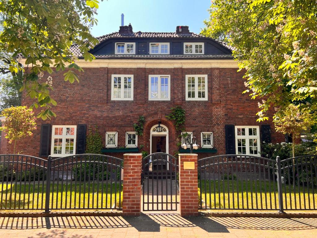 uma casa de tijolos com um portão em frente em Villa am Park em Bremerhaven