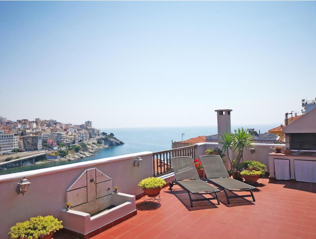 Un balcón con sillas y vistas al océano. en Old-Town Roof-Garden Suite, en Kavala
