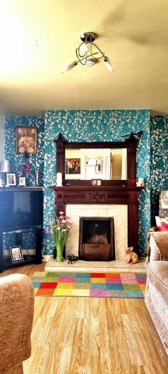a living room with a fireplace and a mirror at The Cosy Cottage in Craigavon