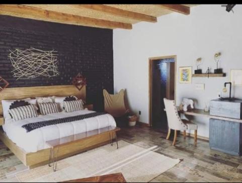 um quarto com uma cama grande e uma secretária em Tierra Madre Hotel Boutique em Comonfort