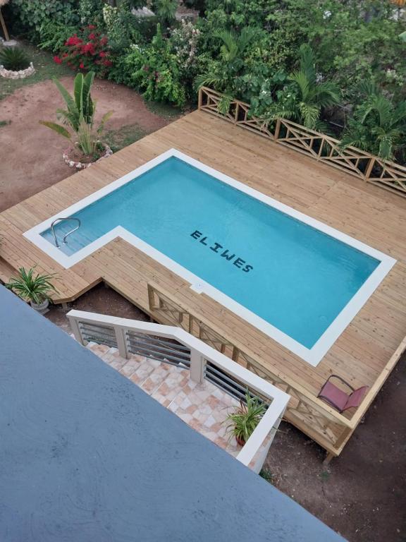 una terrazza in legno con vista sulla piscina. di Eliwes Villa a Treasure Beach