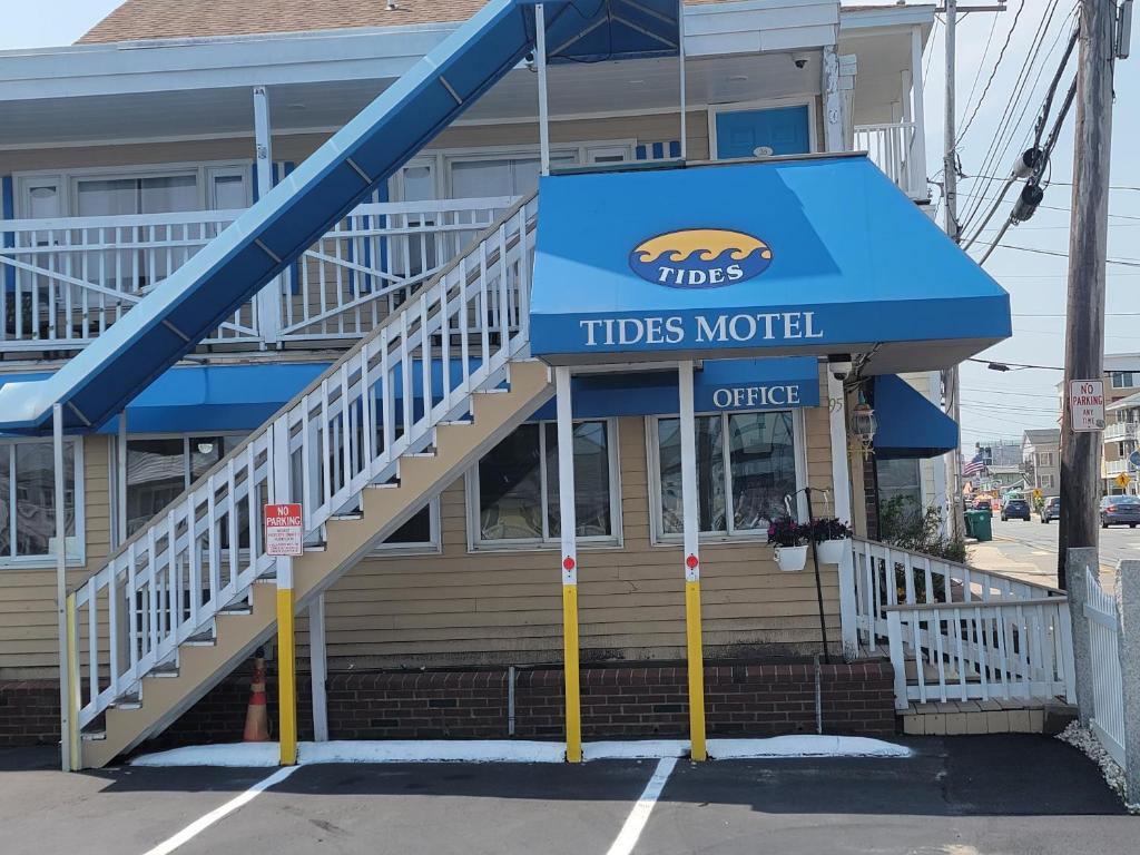 - un restaurant de motel avec un auvent bleu et des escaliers dans l'établissement Tides Motel - Hampton Beach, à Hampton Beach