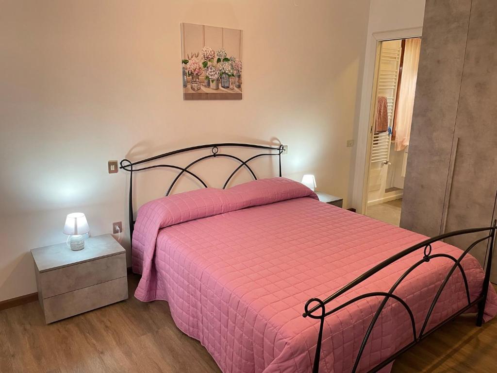 a bedroom with a bed with a pink bedspread at Appartamento Belvedere in Perugia