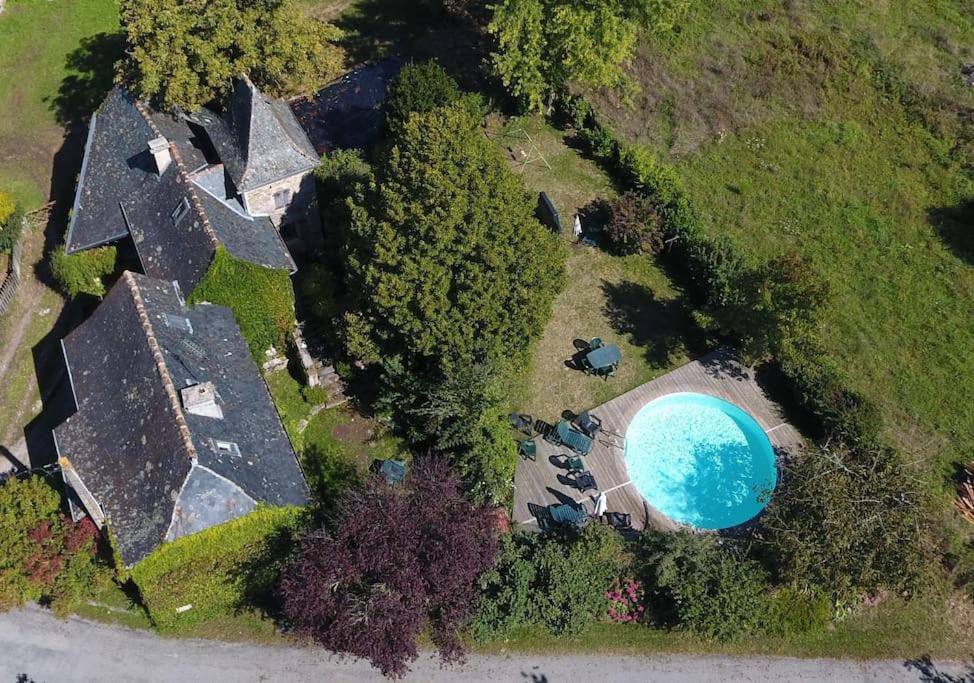 Cette chambre offre une vue sur une maison dotée d'une piscine bleue. dans l'établissement Gite LaMothe en Aveyron, à Salles-Courbatiès