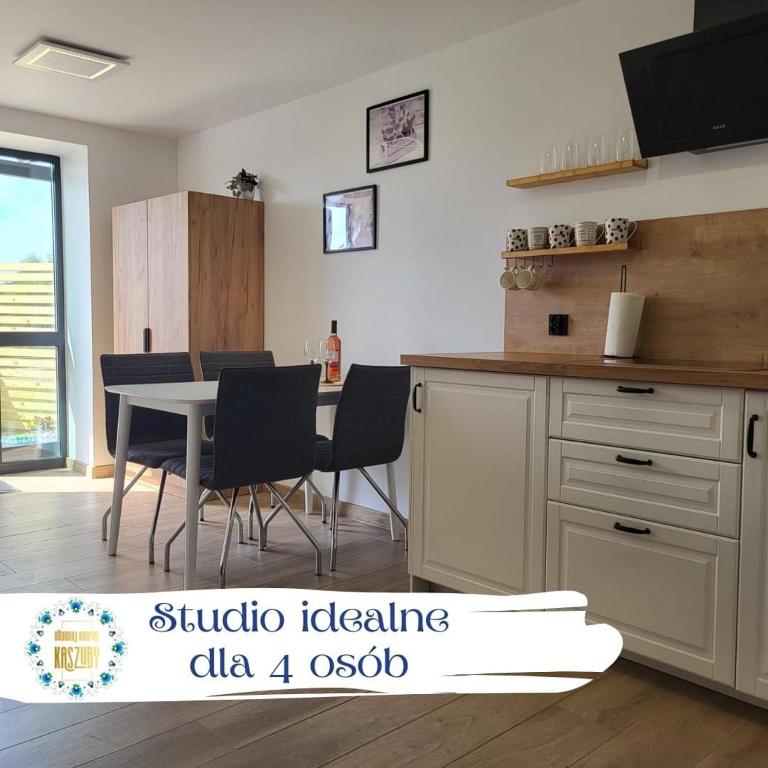 a kitchen with a table and chairs in a room at Studio 4-osobowe in Gowidlino