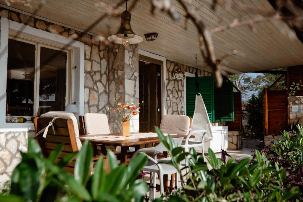 een patio met een tafel en stoelen op een veranda bij Villa Zdena in Rogač