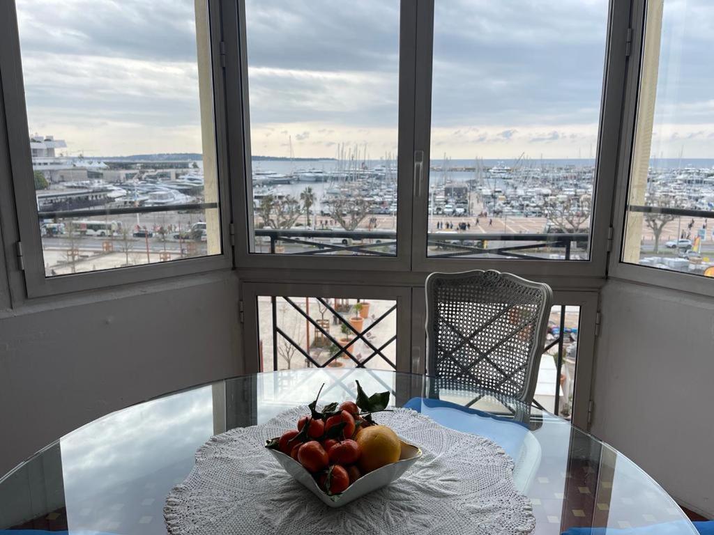 un bol de fruta en una mesa de cristal frente a las ventanas en Cannes Privat Residence Holiday Apartments, en Cannes
