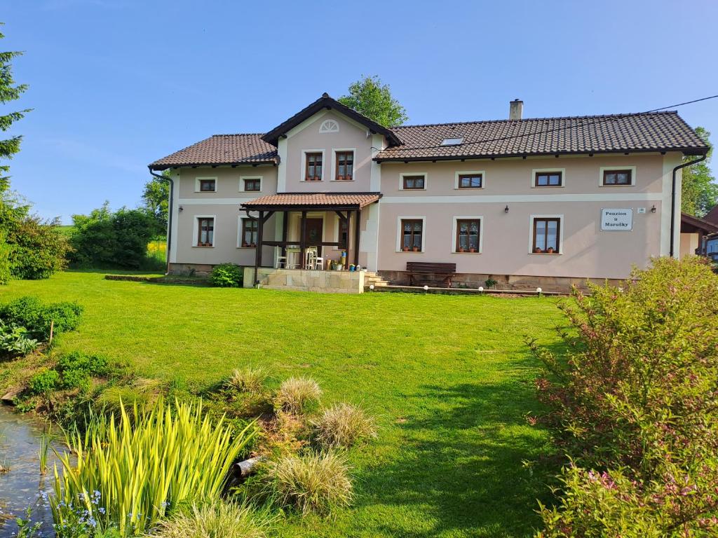 Božanov的住宿－Rekreační dům u Marušky，一座带草地庭院的大型白色房屋