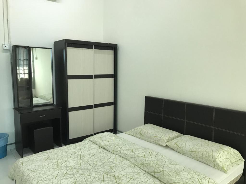 Schlafzimmer mit einem Bett, einer Kommode und einem Spiegel in der Unterkunft 365 House by D'Laksamana in Malakka