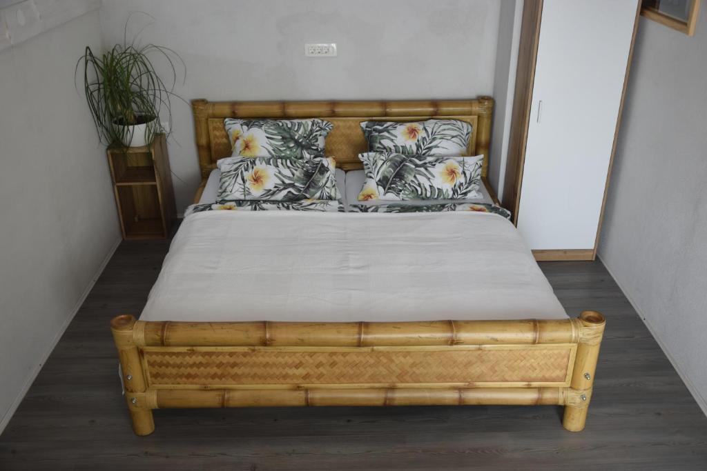 1 cama con marco de madera y almohadas en Catalina Lesce-Bled, en Lesce