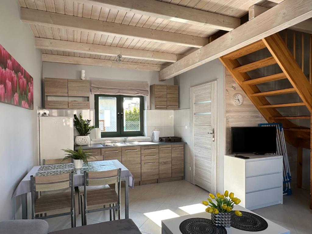 une cuisine et une salle à manger avec une table et des chaises dans l'établissement Domki i apartamenty Mila, à Sarbinowo