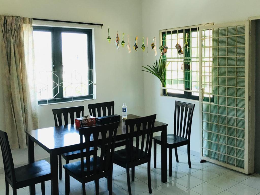 una sala da pranzo con tavolo e sedie in legno di 365 by D'Laksamana a Malacca