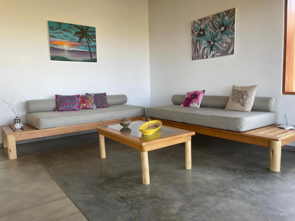 uma sala de estar com dois sofás e uma mesa em villa colibri em Los Órganos