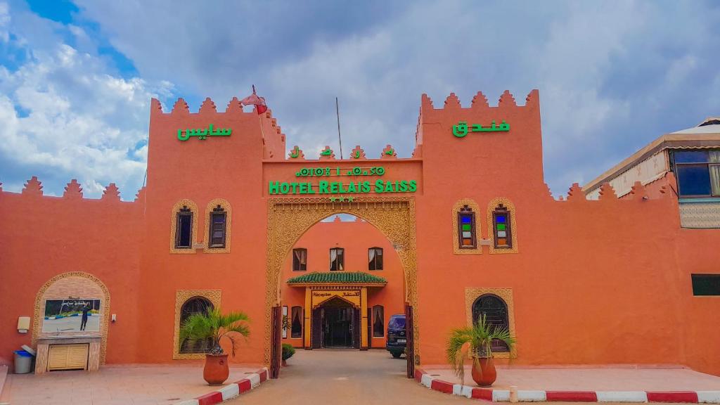 un gran edificio naranja con una entrada arqueada en Hôtel Relais Saiss, en Sefrou