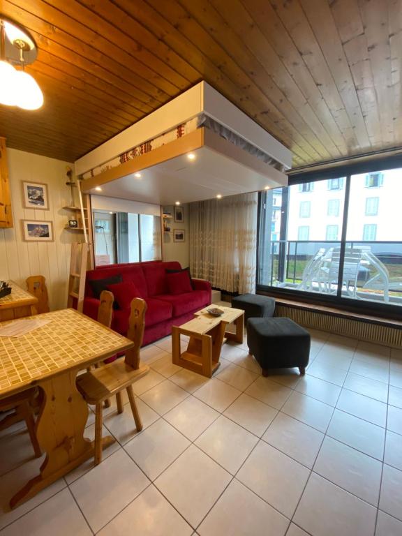 ein Wohnzimmer mit einem roten Sofa und einem Tisch in der Unterkunft Ladybird Inn in Chamonix-Mont-Blanc