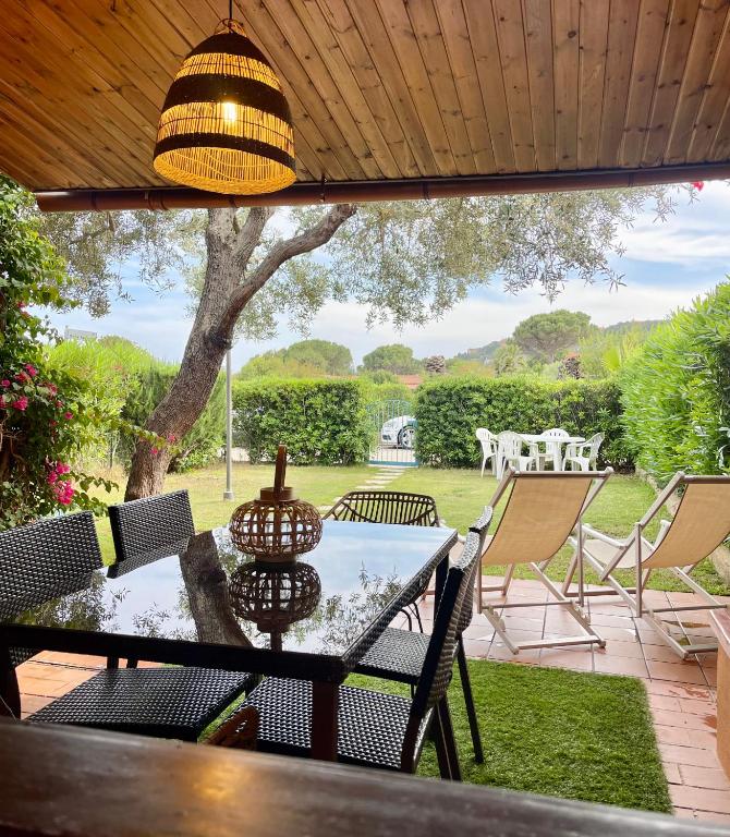 a table and chairs on a patio with a view of a yard at Domu Mea 1 min a Piedi dal Mare in Costa Rei