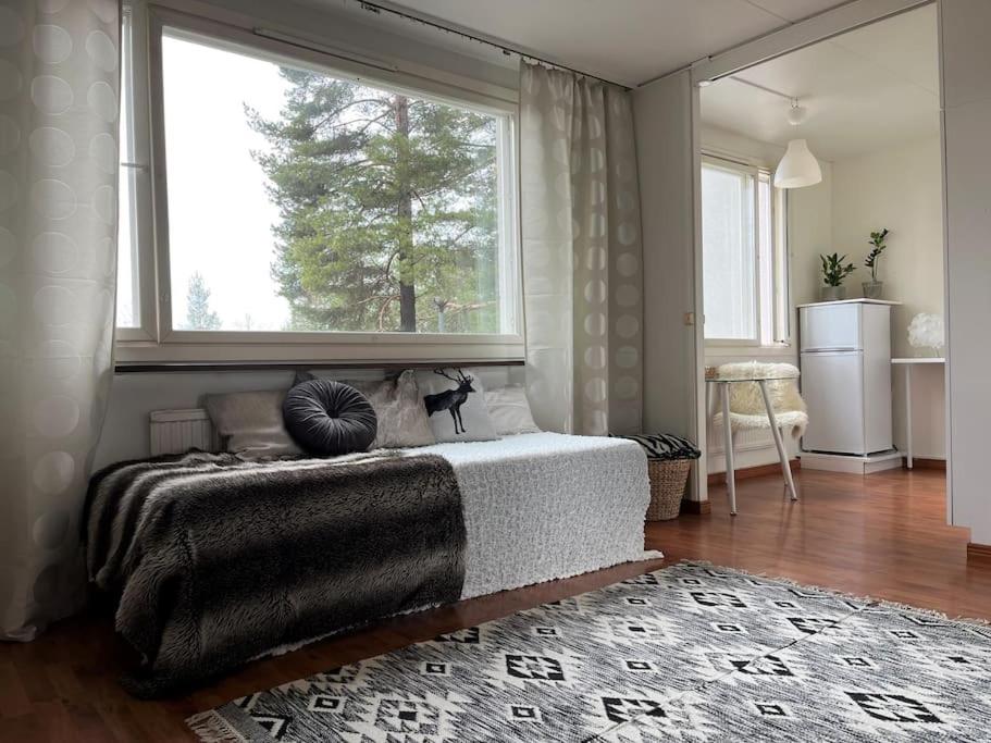 ein Schlafzimmer mit einem Bett und einem großen Fenster in der Unterkunft Studio next to metrostation in Espoo