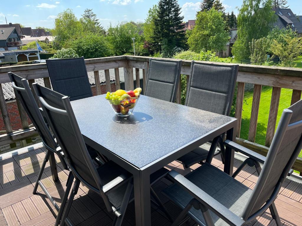 een tafel en stoelen op een terras met een fruitschaal bij Ferienhaus Beerennest in Butjadingen