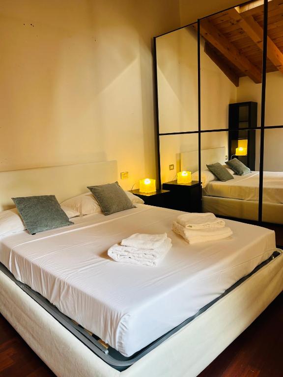 a large white bed in a room with mirrors at Vittoria Verona in Verona