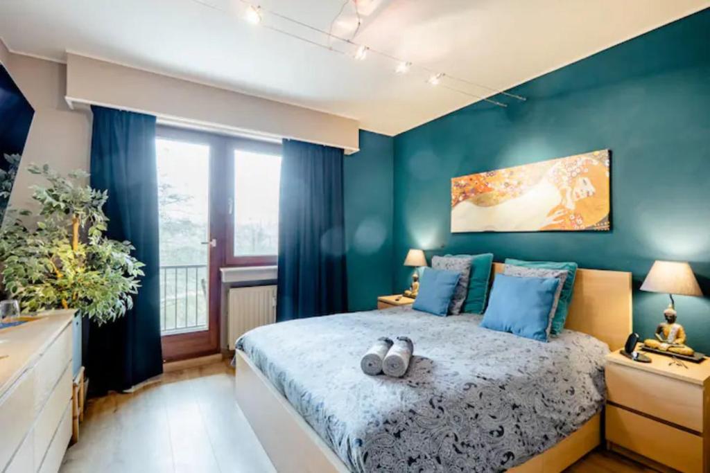 a bedroom with a large bed with blue walls at Homestay in a nice flat in Mondorf-les-Bains