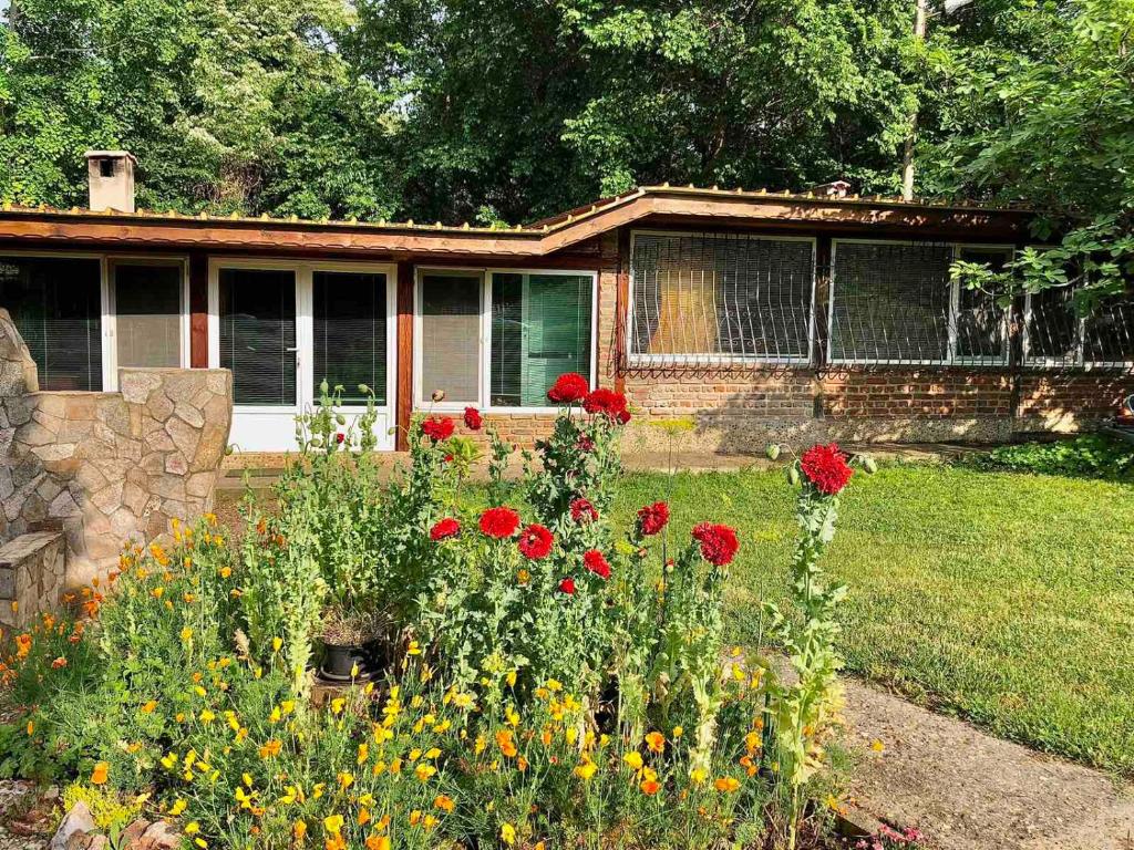 un jardín con flores frente a una casa en Самостоятелна къща за гости на 10 минути от плажа, en Varna