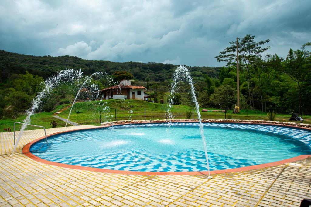 a pool with two water fountains in a park at Caney 2 in Moniquirá