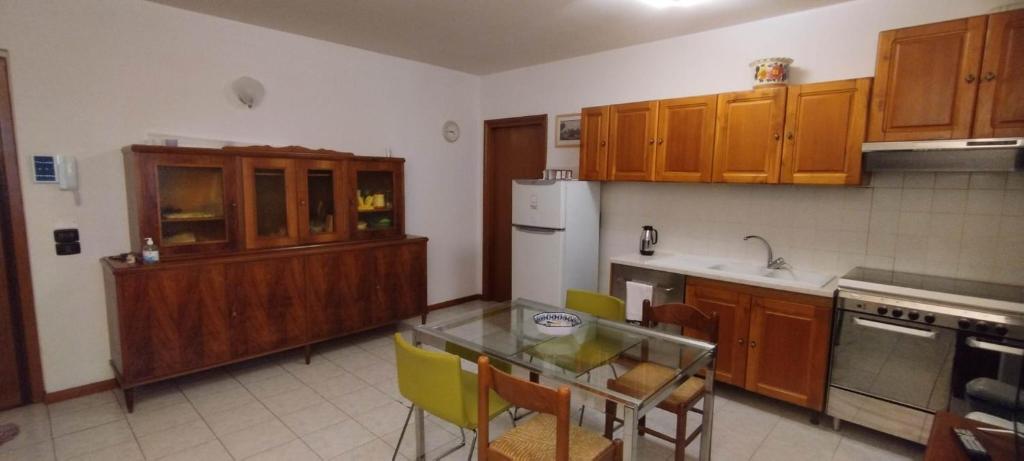a kitchen with wooden cabinets and a glass table with chairs at Perugino Apartament in Florence