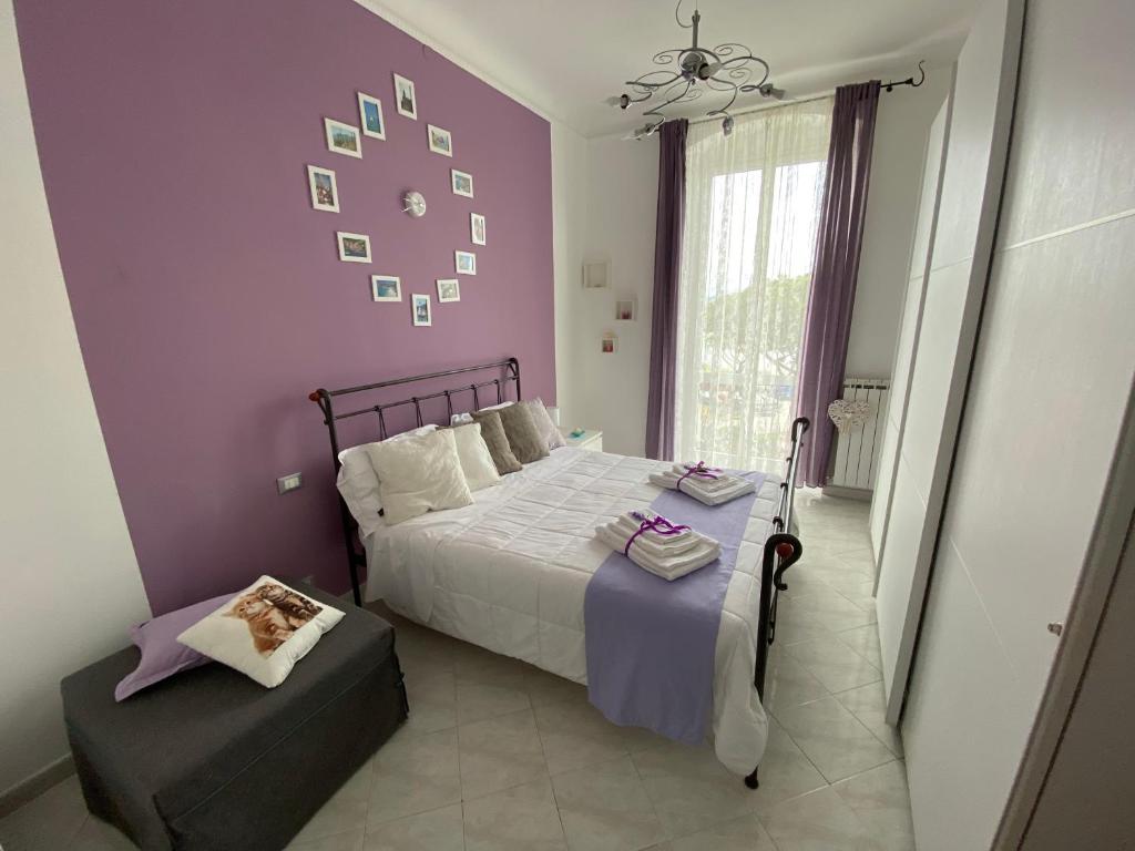 una camera con letto e parete viola di Stella di Mare a La Spezia