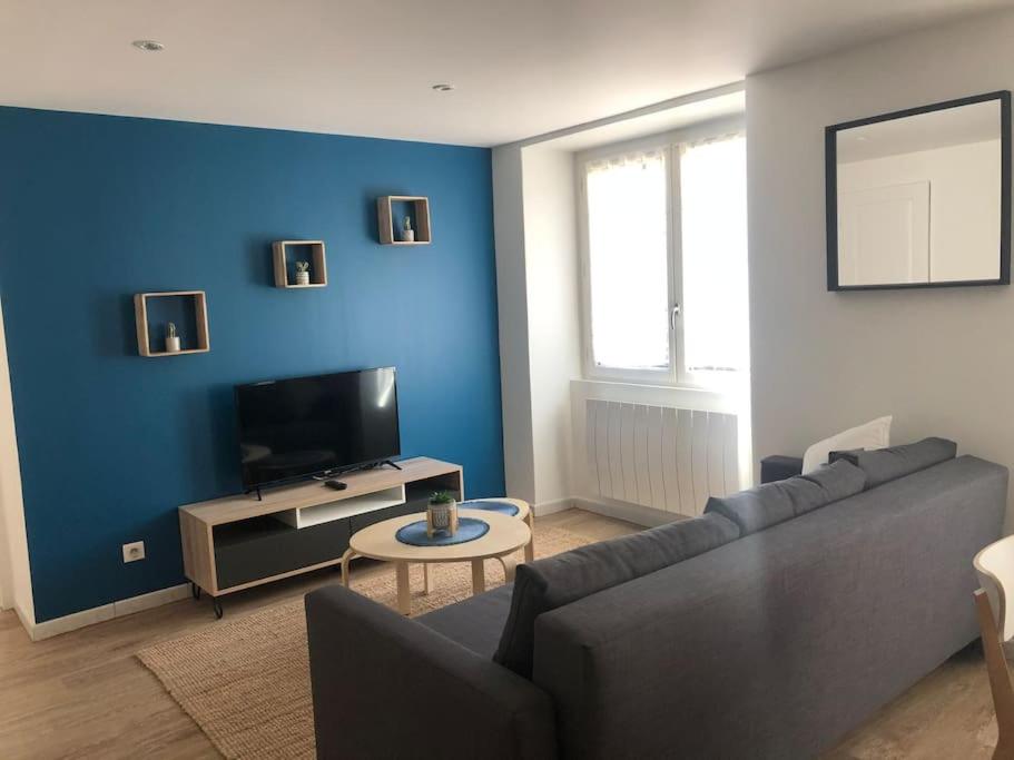 a living room with a couch and a flat screen tv at Superbe Appartement in La Côte-Saint-André