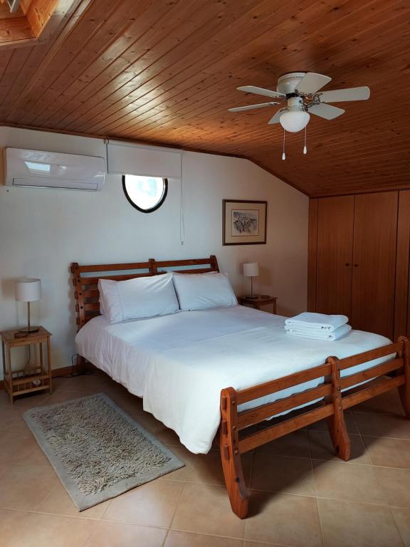 Casa Vida Alegre في برازيريس: غرفة نوم بسرير كبير مع مروحة سقف