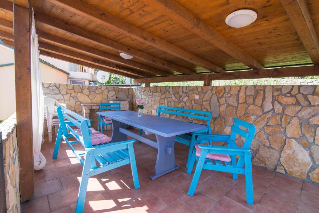 a blue table and chairs on a stone wall at Ivana C6 in Veli Lošinj