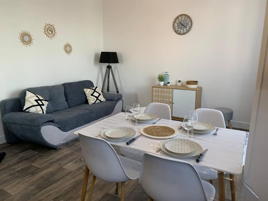 un salon avec une table avec des chaises et un canapé dans l'établissement Appartement rénové à 200m de la plage, à Châtelaillon-Plage
