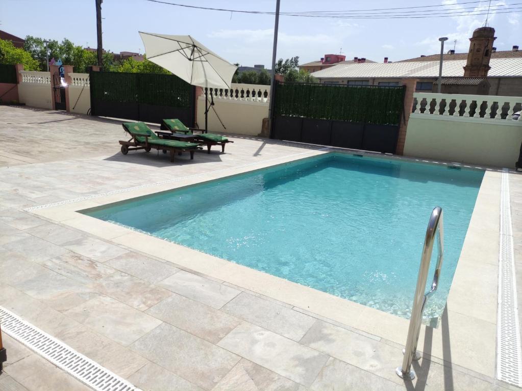 a swimming pool with two chairs and an umbrella at Casa en Empordà con piscina grande propia in Báscara
