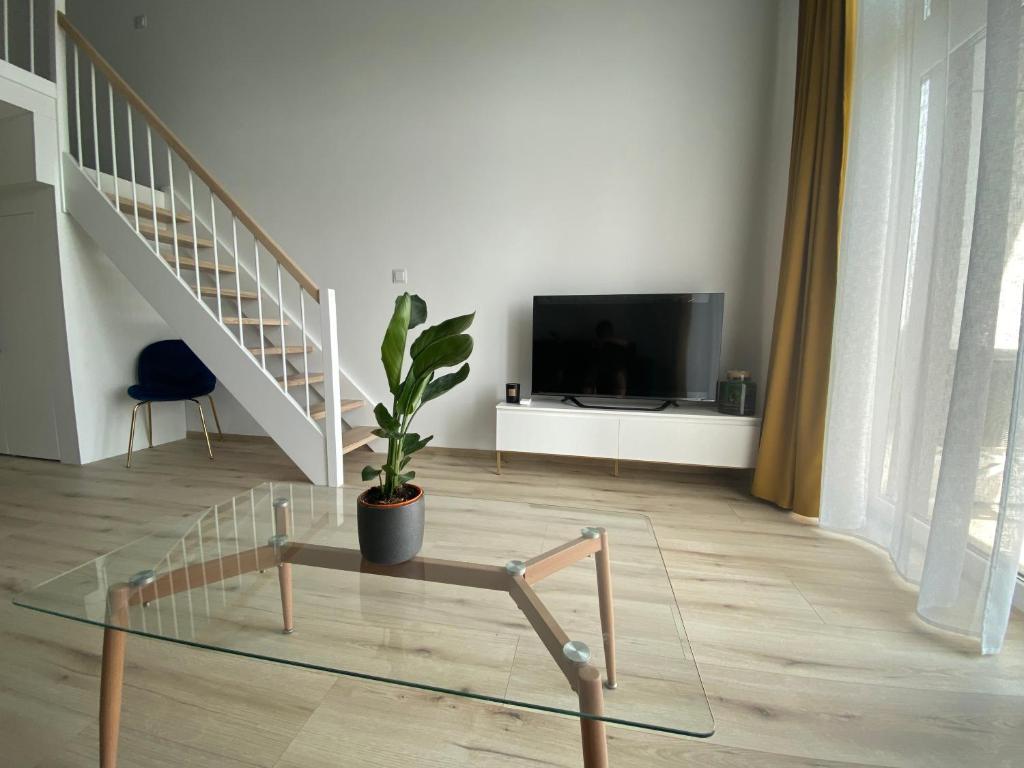 a living room with a glass table and a tv at Apartament Wrocław-Lotnisko in Wrocław