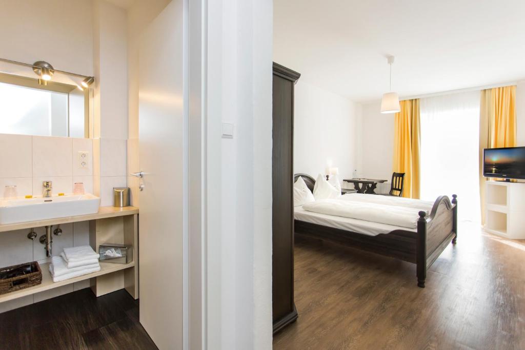 sypialnia z łóżkiem, umywalką i lustrem w obiekcie Hotel/Pension Kaya 