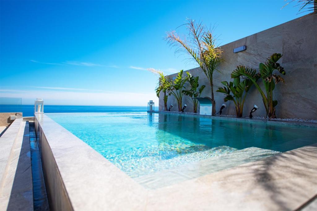a swimming pool with the ocean in the background at Villa Zambudio in San José