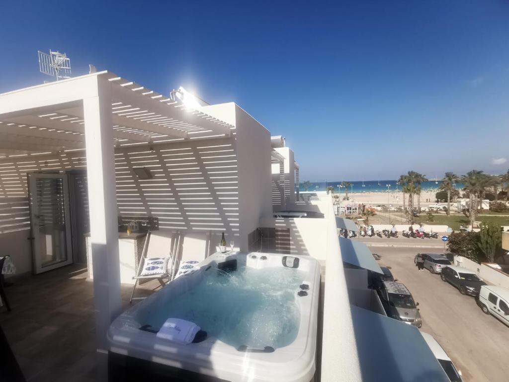 a hot tub on the balcony of a beach house at MARE e Terra Holiday fronte mare in San Vito lo Capo