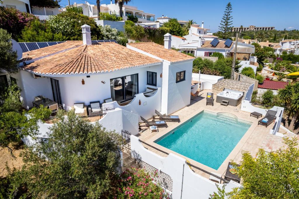 ein Bild einer Villa mit einem Pool in der Unterkunft CoolHouses Algarve, Luz, 3 Bed villa, 1 bed studio, heated pool & jacuzzi, sea views, Casa Pequena in Luz