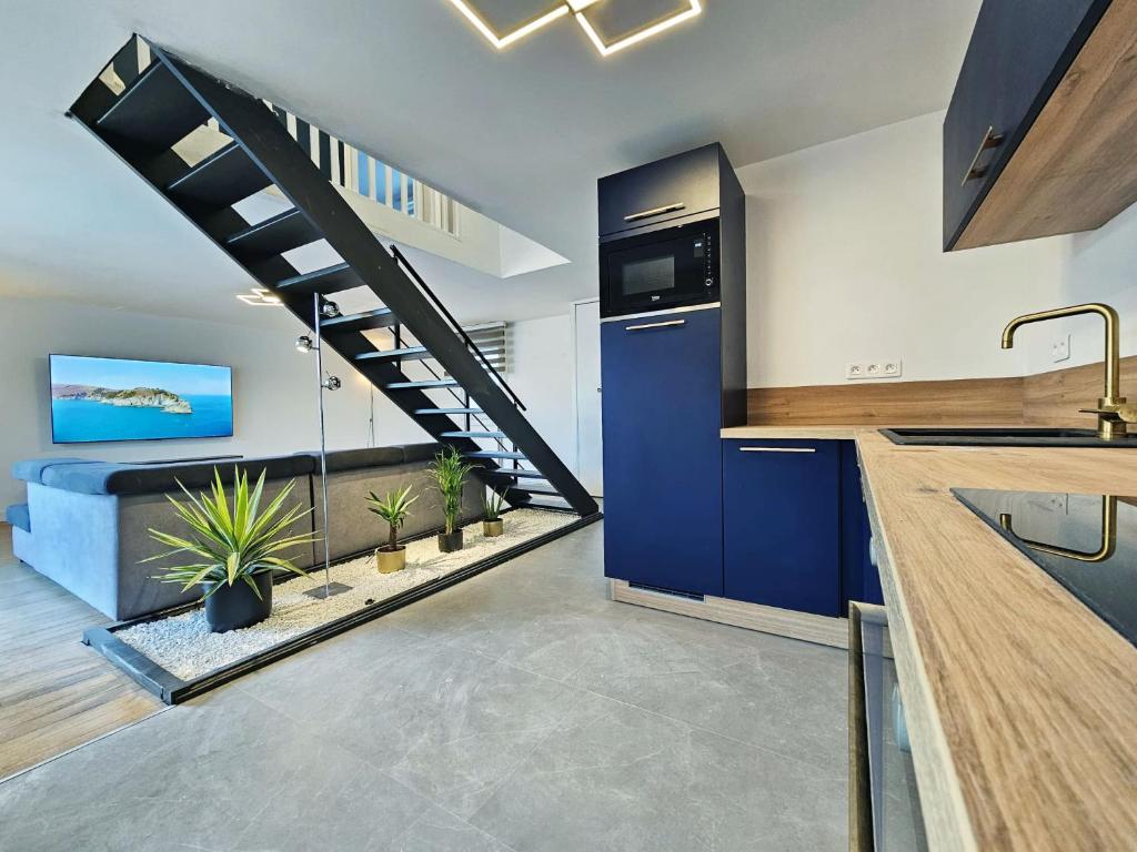 une cuisine avec des armoires bleues et un escalier en colimaçon dans l'établissement Royal Terrace - Maison plage & Parking privé, à Dunkerque