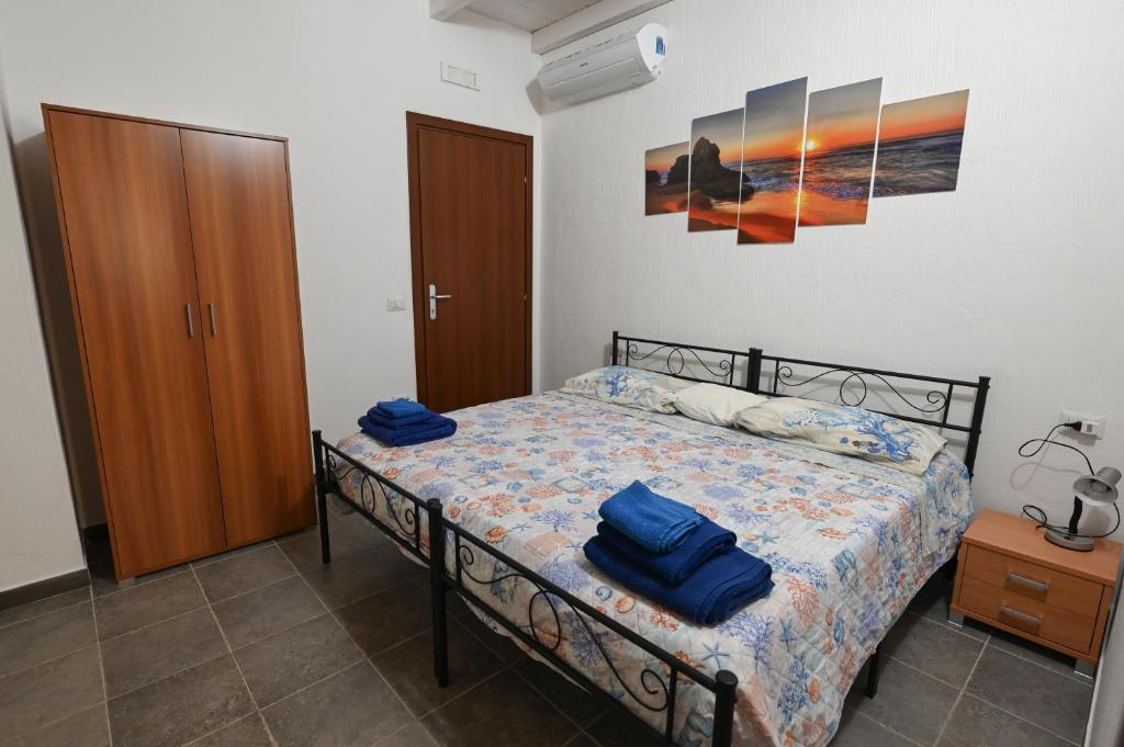 a bedroom with a bed with blue towels on it at B&B Su Neulagi in Triei