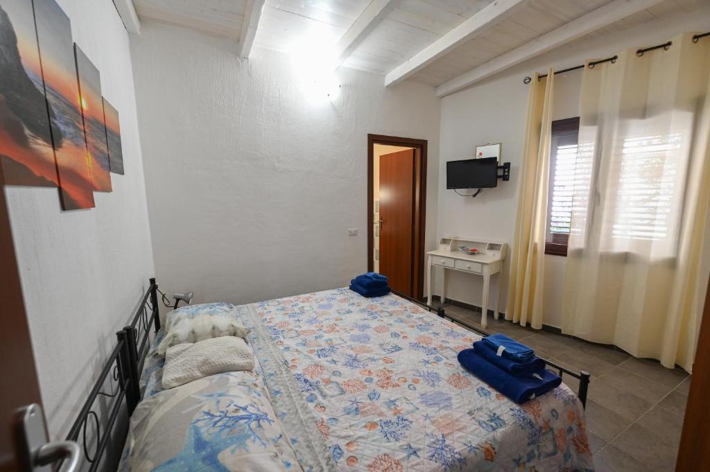 a bedroom with a bed and a television in it at B&B Su Neulagi in Triei