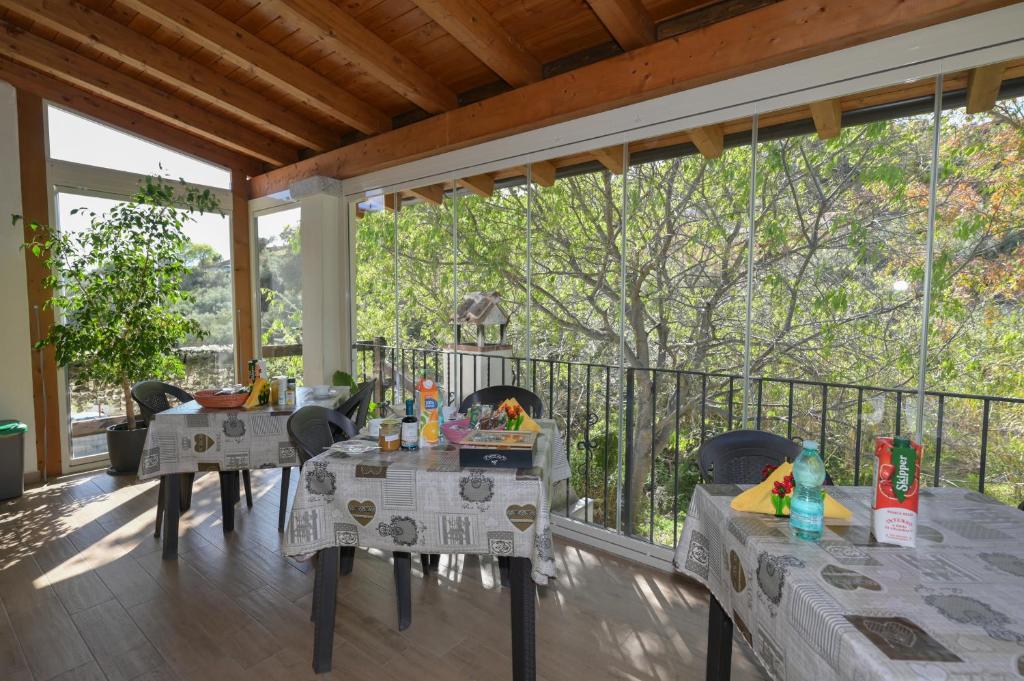 een patio met tafels en stoelen op een balkon bij B&B Su Neulagi in Triei