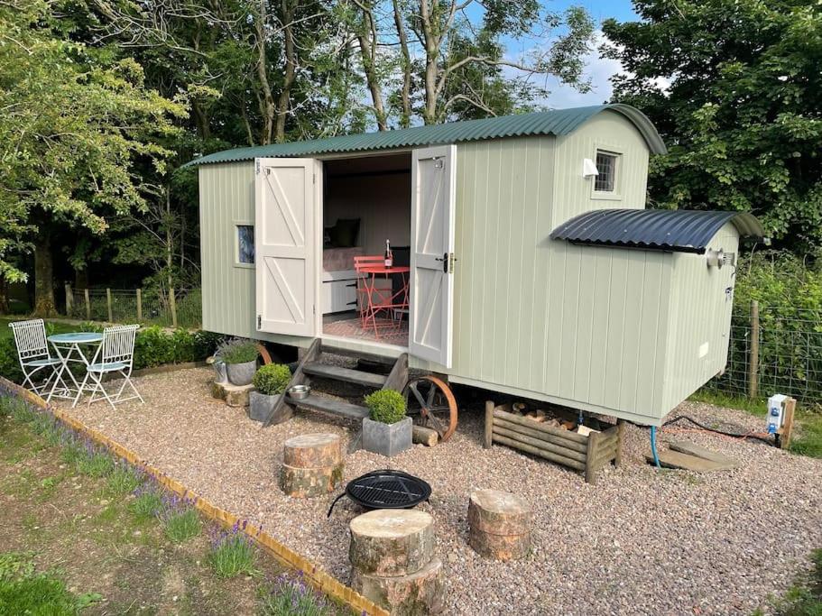 a green tiny house with a table and a grill at The Rookery in Lothersdale