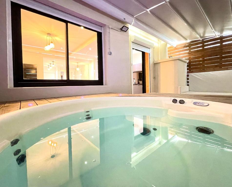 a large bath tub in a room with a window at loft romantique spa in Nice