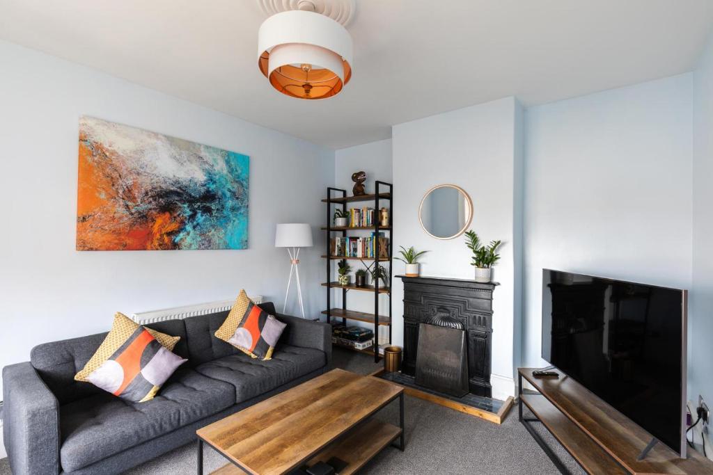 ein Wohnzimmer mit Couch und Kamin in der Unterkunft Eden Cottage - 9 Guests, Sea Views, Central Cowes, Ferry Deal in Cowes