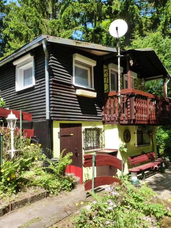 ein kleines Haus mit einer Veranda und einem Balkon in der Unterkunft Ferienhaus Tanneneck in Pottum