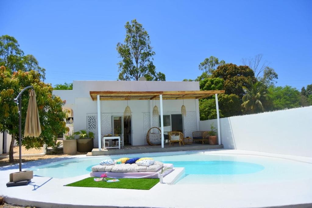 a villa with a swimming pool and a house at Mykolodge Majunga in Amborovy