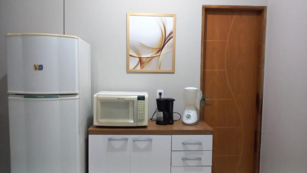 uma cozinha com um frigorífico e um micro-ondas em Casa Confortável em Caruaru