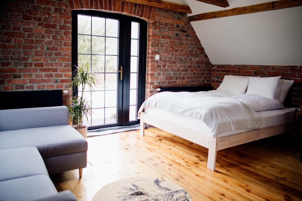 a bedroom with a bed and a brick wall at Dolina Zdrowia u Skrzypków in Wleń